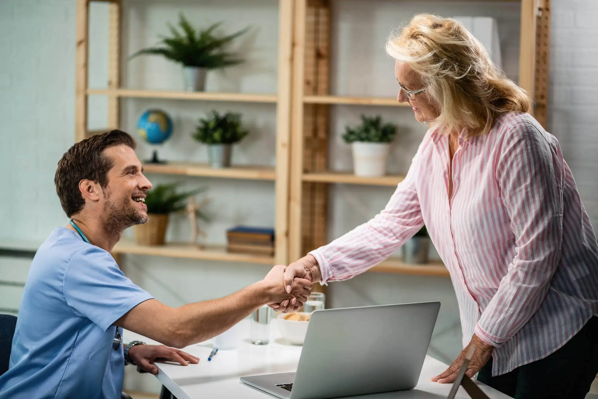 medical assistant shaking hand with a woman