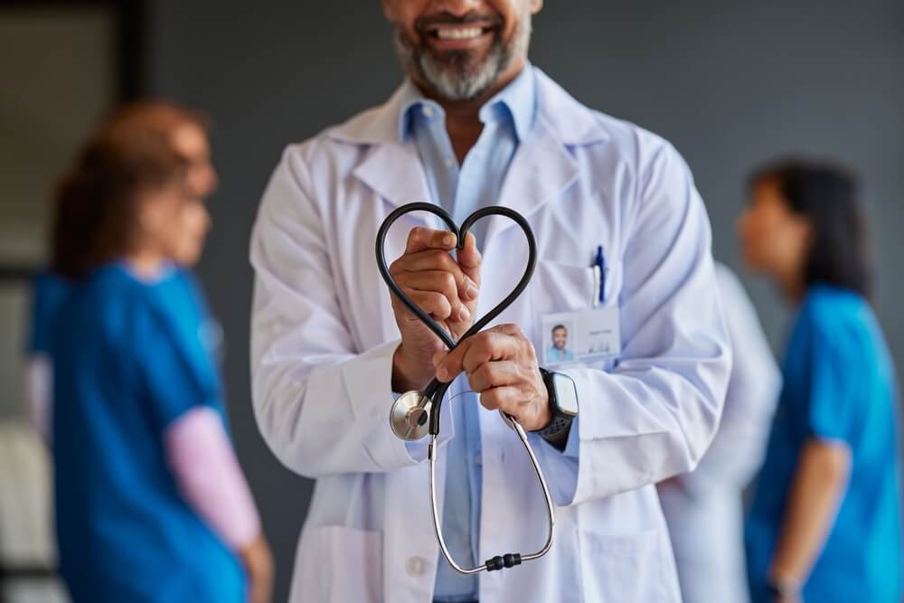 Chiropractic Assistant smiling and showing heart sign with his stethoscope