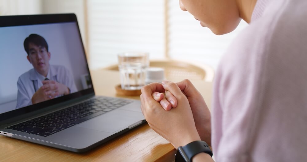 Psychiatric Mental Health Nurse Practitioner working remotely on her laptop