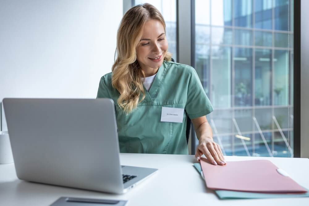 Healthcare administrator scheduling appointment and verifying insurance information on computer