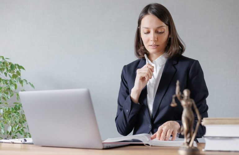 Professional virtual legal assistant handling legal documents and client communication using a laptop remotely.