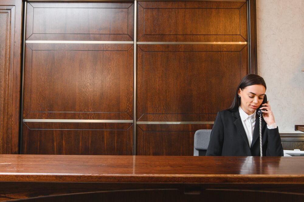 Remote hospitality virtual assistant managing hotel operations on computer