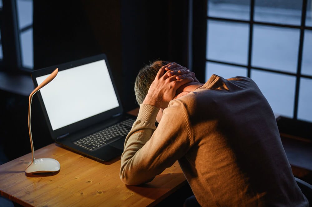 Remote worker feeling stressed and overwhelmed while working from home showing signs of burnout