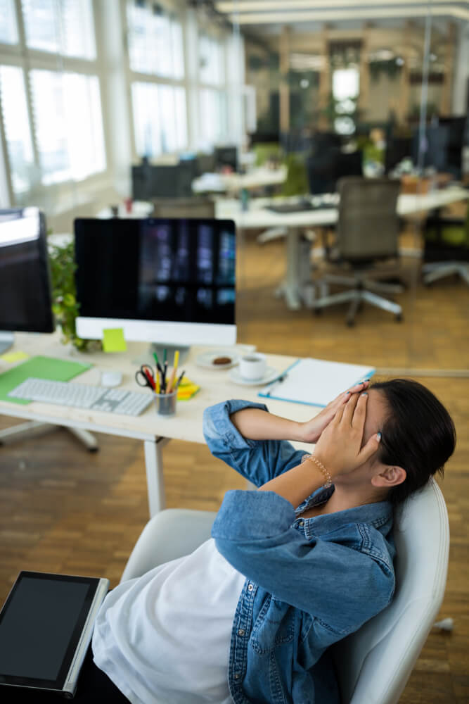 Tired professional rubbing eyes with fatigue while working on computer at home