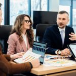 Business development representatives and sales development representatives discussing lead generation strategies in a modern office.