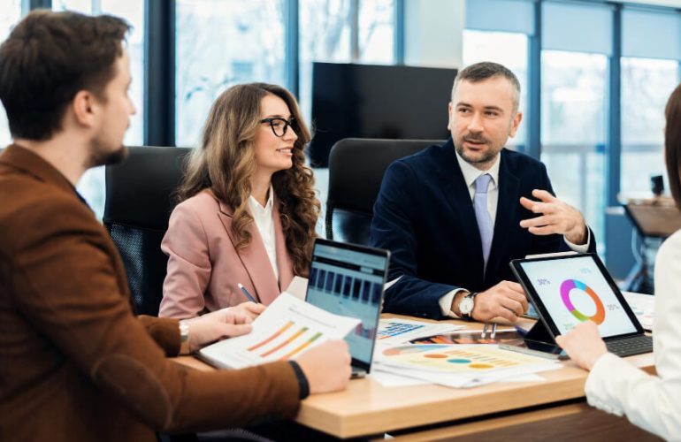 Business development representatives and sales development representatives discussing lead generation strategies in a modern office.