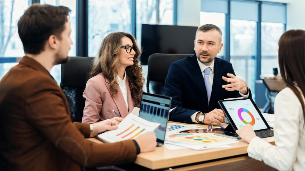 Business development representatives and sales development representatives discussing lead generation strategies in a modern office.